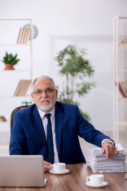 Eski erkek çalışanımız teneffüste kahve içiyor.