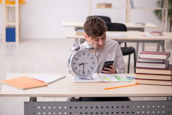 Alumno masculino en concepto de gestión del tiempo — Foto de Stock