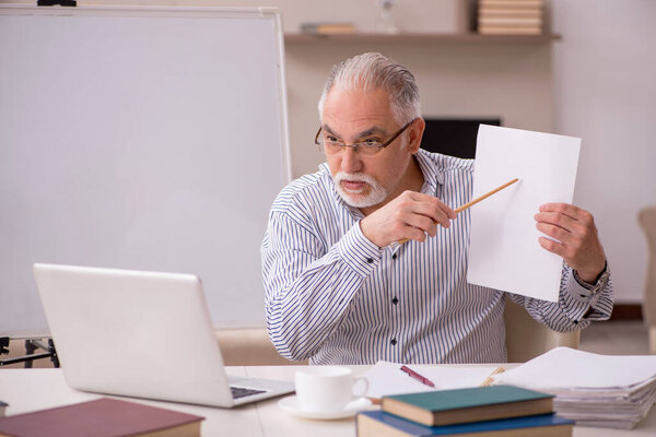Old male employee working from home during pandemic
