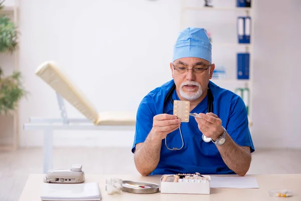 Klinikte çalışan yaşlı erkek doktor. — Stok fotoğraf