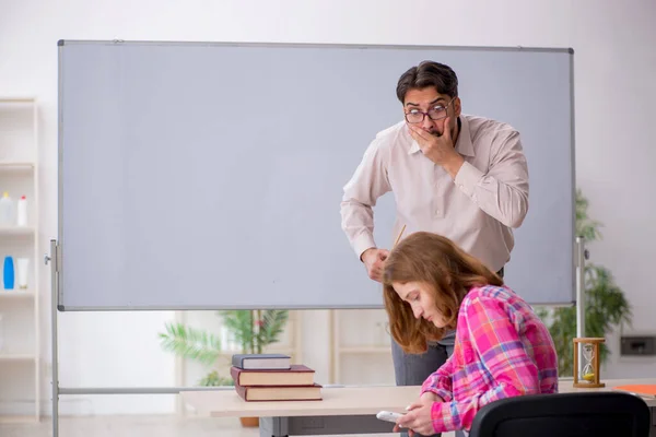 Jong man leraar en roodharige meisje in de klas — Stockfoto