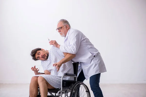 Yaşlı erkek doktor psikiyatristi engelli hastaları muayene ediyor. — Stok fotoğraf