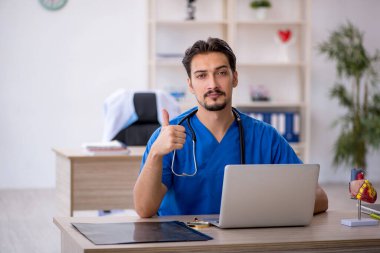 Klinikte çalışan genç erkek doktor.