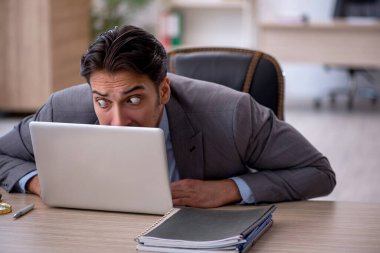 Ofiste çalışan genç bir erkek.