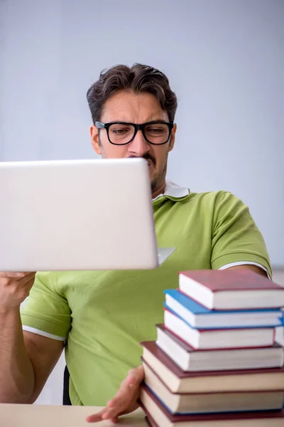 Jonge mannelijke student bereidt zich voor op examens in de klas — Stockfoto