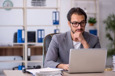 Ofiste çalışan genç bir erkek.