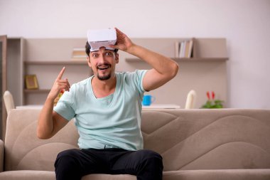 Evde sanal gözlük takan genç bir öğrenci.