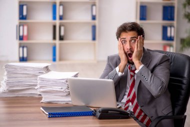 Ofisteki aşırı işten memnun olmayan genç bir erkek işçi.