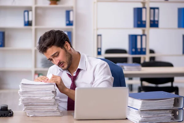 Junge männliche Mitarbeiter und zu viel Arbeit im Büro — Stockfoto