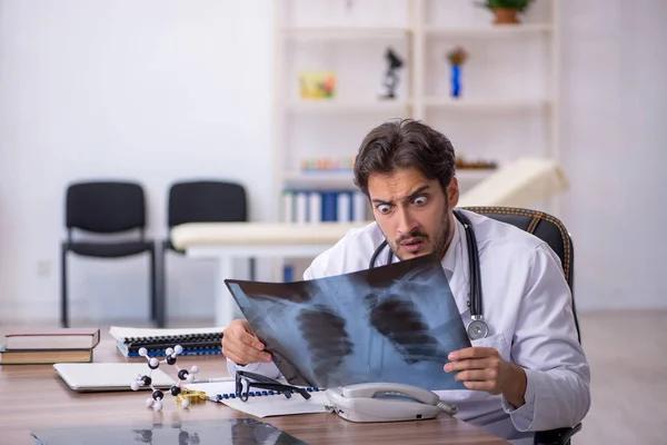 Ung manlig röntgenläkare som arbetar på kliniken — Stockfoto