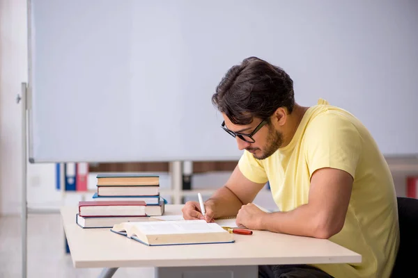 Jovem estudante se preparando para exames em sala de aula — Fotografia de Stock