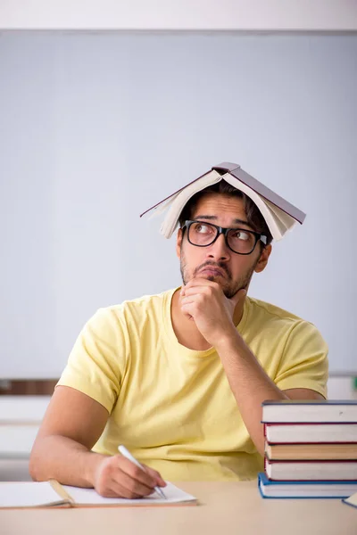 Joven estudiante masculino preparándose para los exámenes en el aula — Foto de Stock