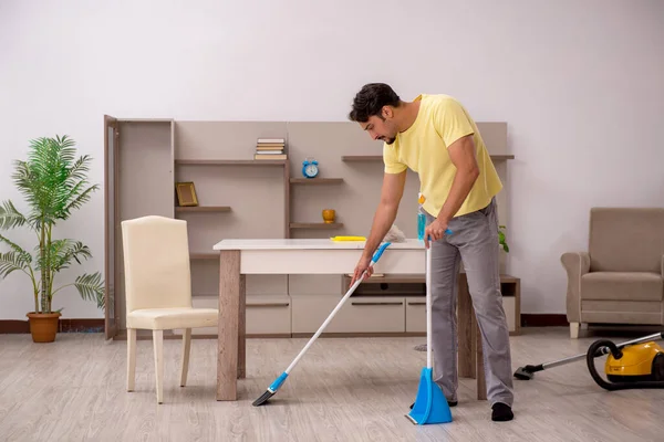 Giovane uomo che fa i lavori domestici a casa — Foto Stock