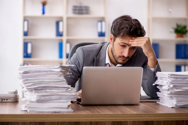 Jovem funcionário masculino infeliz com excesso de trabalho no escritório — Fotografia de Stock