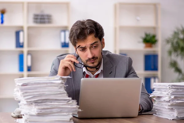 Ung manlig anställd missnöjd med överdrivet arbete på kontoret — Stockfoto