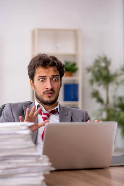 Joven empleado masculino descontento con el trabajo excesivo en la oficina — Foto de Stock