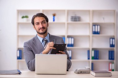 Ofiste çalışan genç bir erkek.