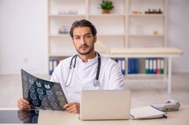 Klinikte çalışan genç bir erkek radyolog.