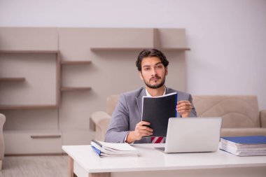 Genç erkek çalışan salgın sırasında evden çalışıyor.