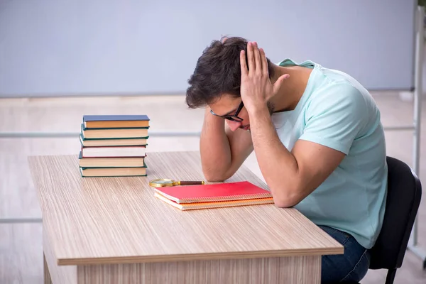 Joven estudiante masculino preparándose para los exámenes en el aula —  Fotos de Stock