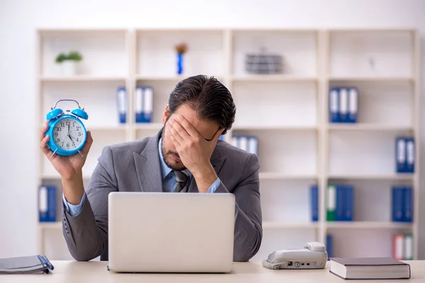 Joven empleado masculino en concepto de gestión del tiempo — Foto de Stock