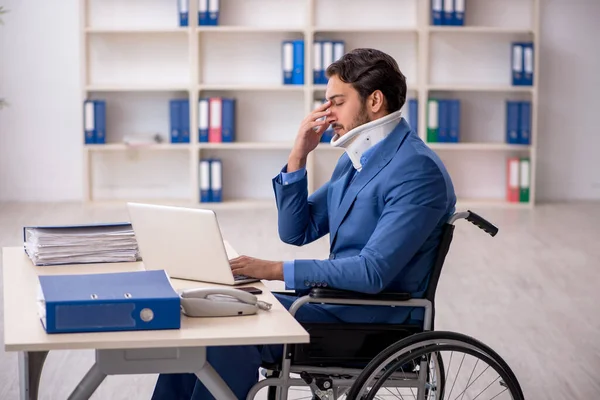 Young male employee after accident sitting at workplace — Stock Photo, Image