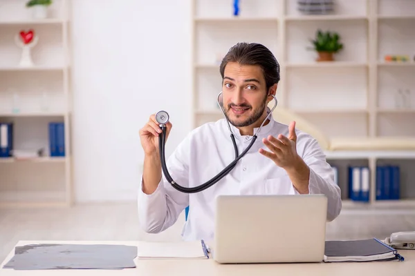 Ung manlig läkare som arbetar på kliniken — Stockfoto