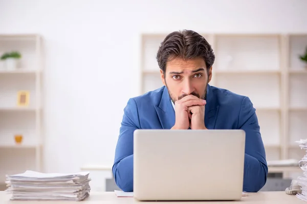 Jonge mannelijke werknemer en te veel werk op kantoor — Stockfoto