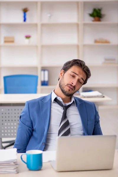 Joven empleado masculino y demasiado trabajo en la oficina — Foto de Stock