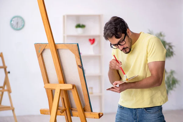Νεαρός που απολαμβάνει τη ζωγραφική στο σπίτι — Φωτογραφία Αρχείου