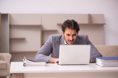 Genç erkek çalışan salgın sırasında evden çalışıyor.