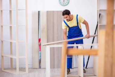 Genç erkek marangoz atölyede çalışıyor.