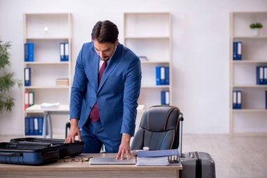 Genç bir erkek işçi iş yerinde geziye hazırlanıyor.