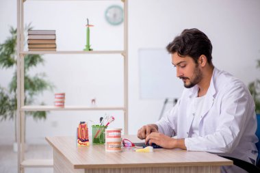 Klinikte çalışan genç erkek dişçi.