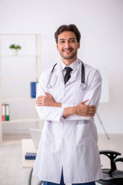 Klinikte çalışan genç erkek doktor.