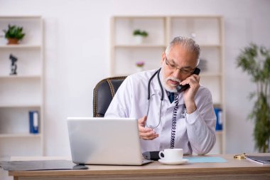 Teletıp konseptinde yaşlı bir doktor.