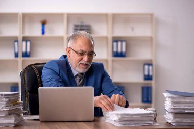 Ofiste çalışan yaşlı bir erkek.