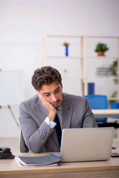 Jovem trabalhador masculino sentado no local de trabalho — Fotografia de Stock