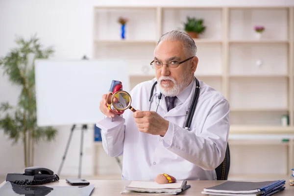 Viejo médico cardiólogo que trabaja en la clínica —  Fotos de Stock