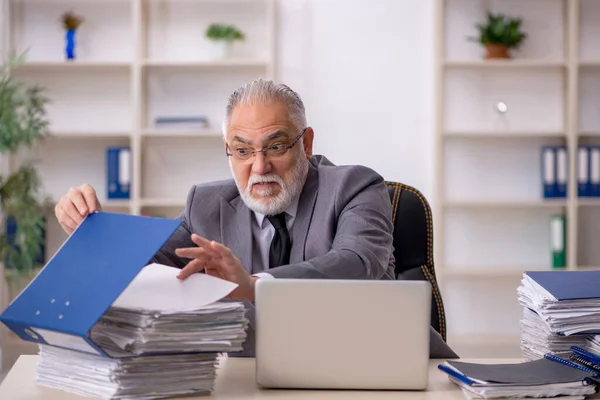 Παλιός υπάλληλος και πολλή δουλειά στο γραφείο. — Φωτογραφία Αρχείου