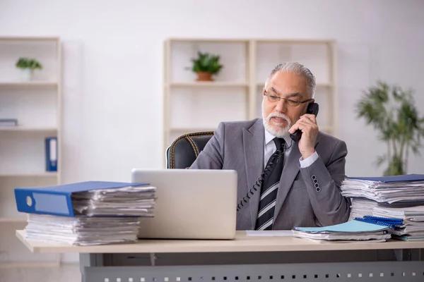 Velho empregado masculino e muito trabalho no escritório — Fotografia de Stock