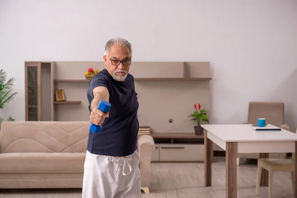 Viejo haciendo ejercicios deportivos en casa —  Fotos de Stock