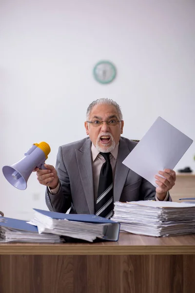 Régi férfi alkalmazott kezében hangosbeszélő az irodában — Stock Fotó