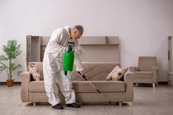 Viejo contratista masculino haciendo control de plagas en casa — Foto de Stock