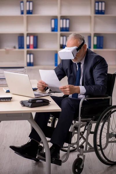 Viejo pierna lesionado empleado masculino usando gafas virtuales en workpla — Foto de Stock