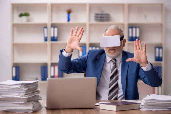 Verouderde mannelijke werknemer draagt virtuele bril in het kantoor — Stockfoto