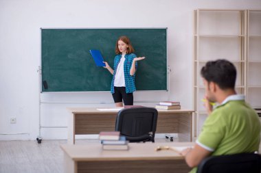 Genç öğretmen ve öğrenci sınıfta.