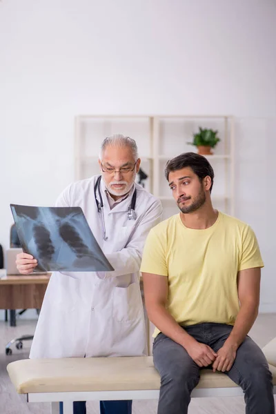 Ung manlig läkare besöker gammal manlig läkare radiolog — Stockfoto