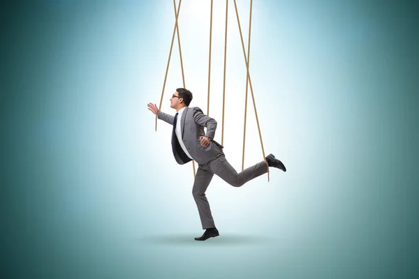 Businessman puppet being manipulated by ropes — Stock Photo, Image