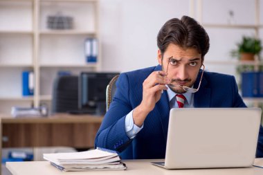 Ofiste çalışan genç bir erkek.